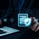 Cybersecurity concept showing a digital shield with checkmark over a laptop, representing data protection and compliance