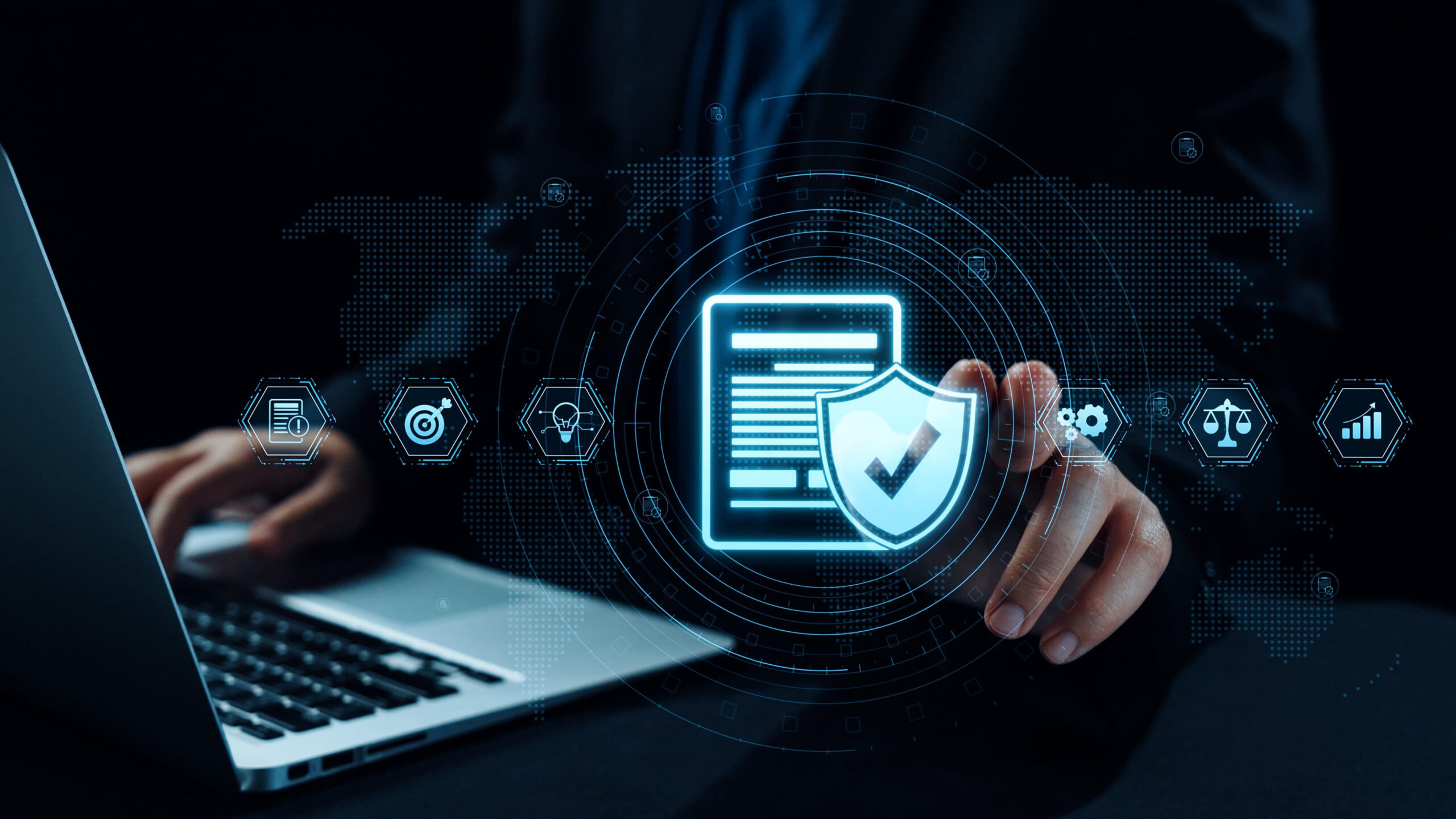 Cybersecurity concept showing a digital shield with checkmark over a laptop, representing data protection and compliance